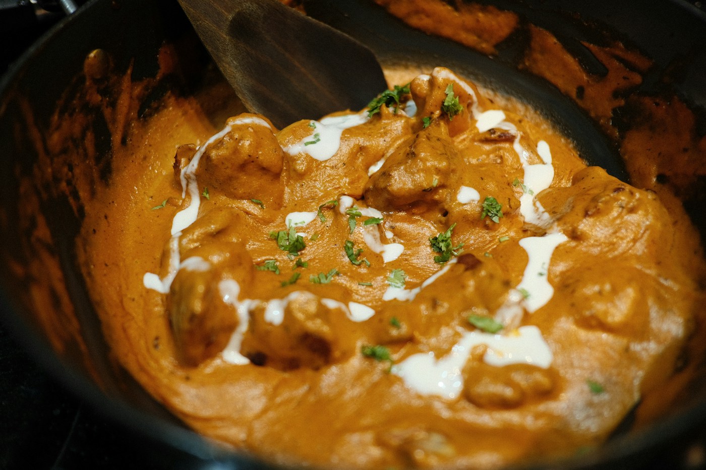 A rich chicken curry garnished with fresh herbs
